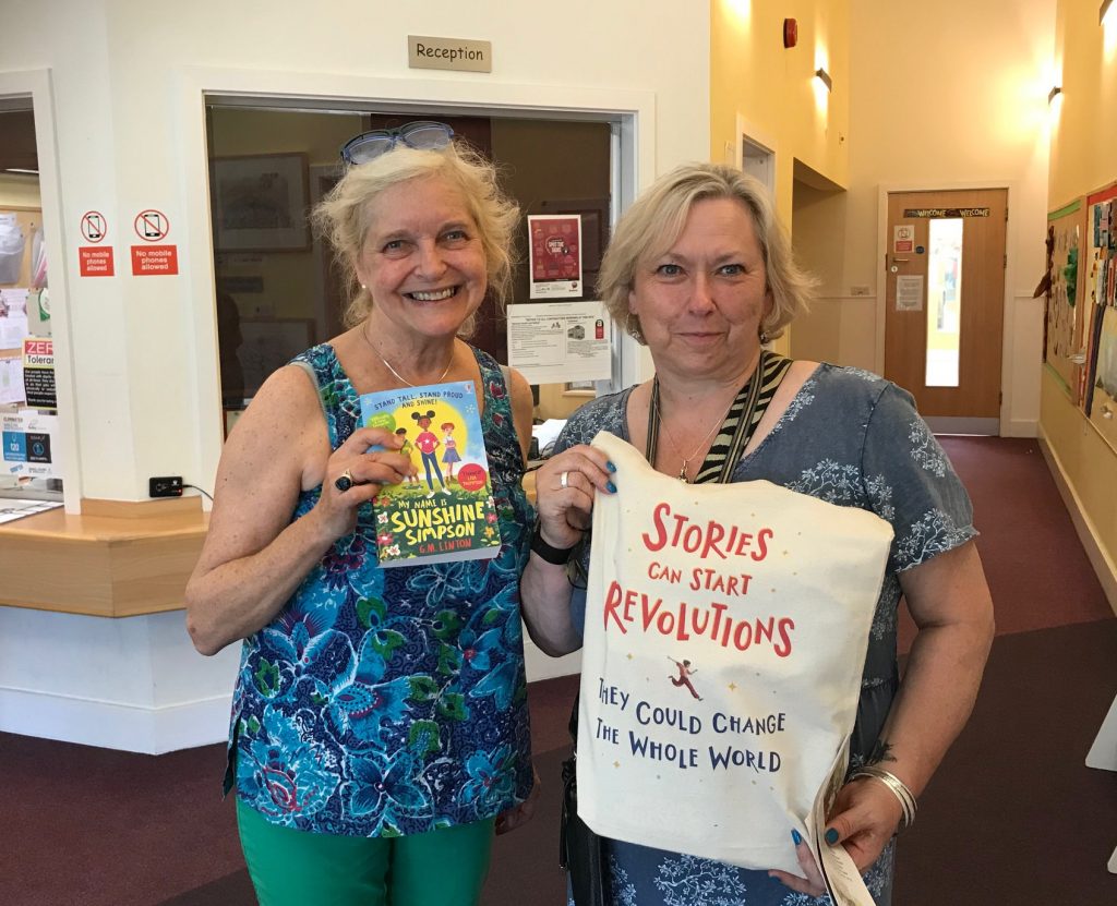 Jackie Holderness presents a bag of nearly new childrens books to Alex at Botley Primary